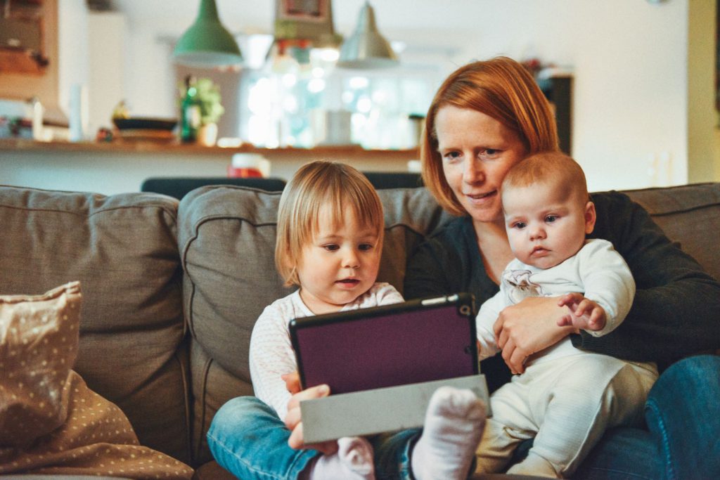 Lege hjem til mor og to barn, som ser på lesebrettet sitt